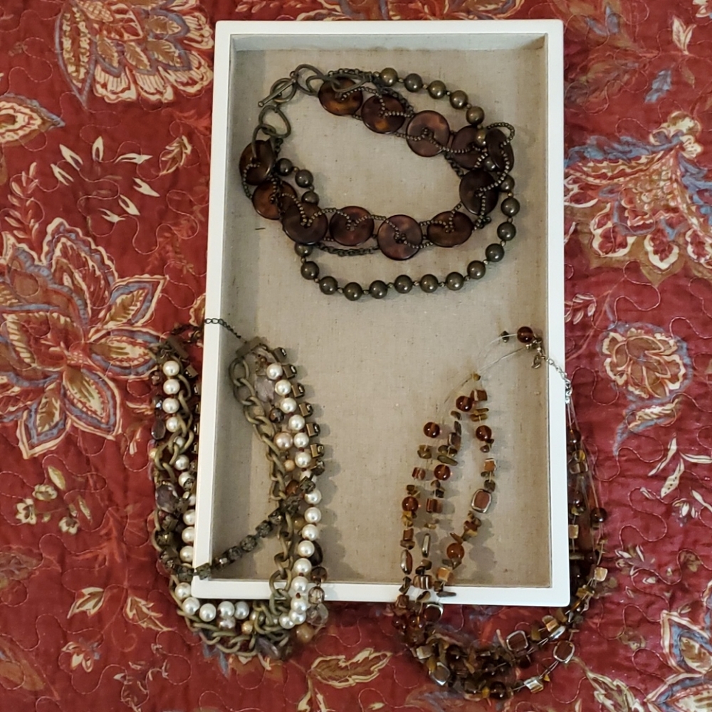 Three brown tone necklaces.